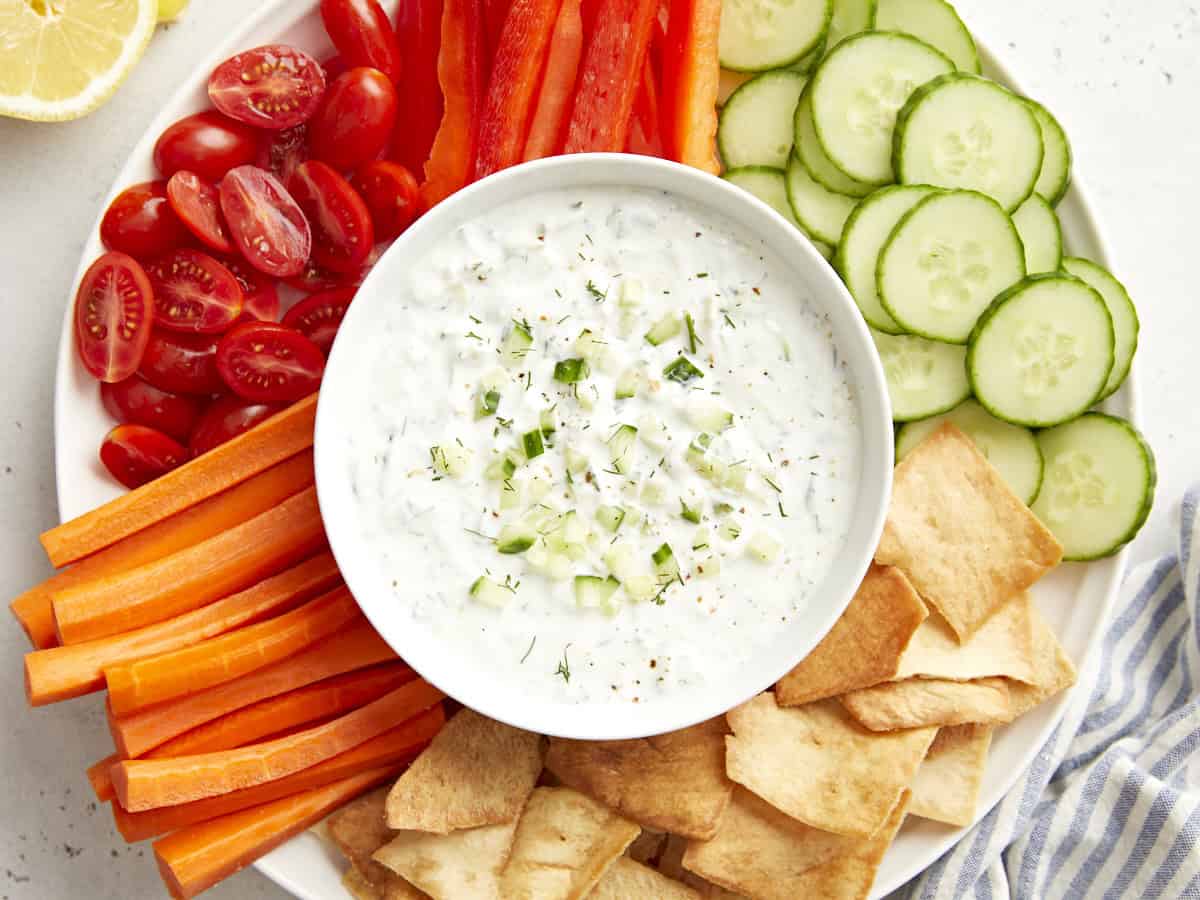 Overhead view of Tzatziki sauce in a serving bowl on a veggie platter.