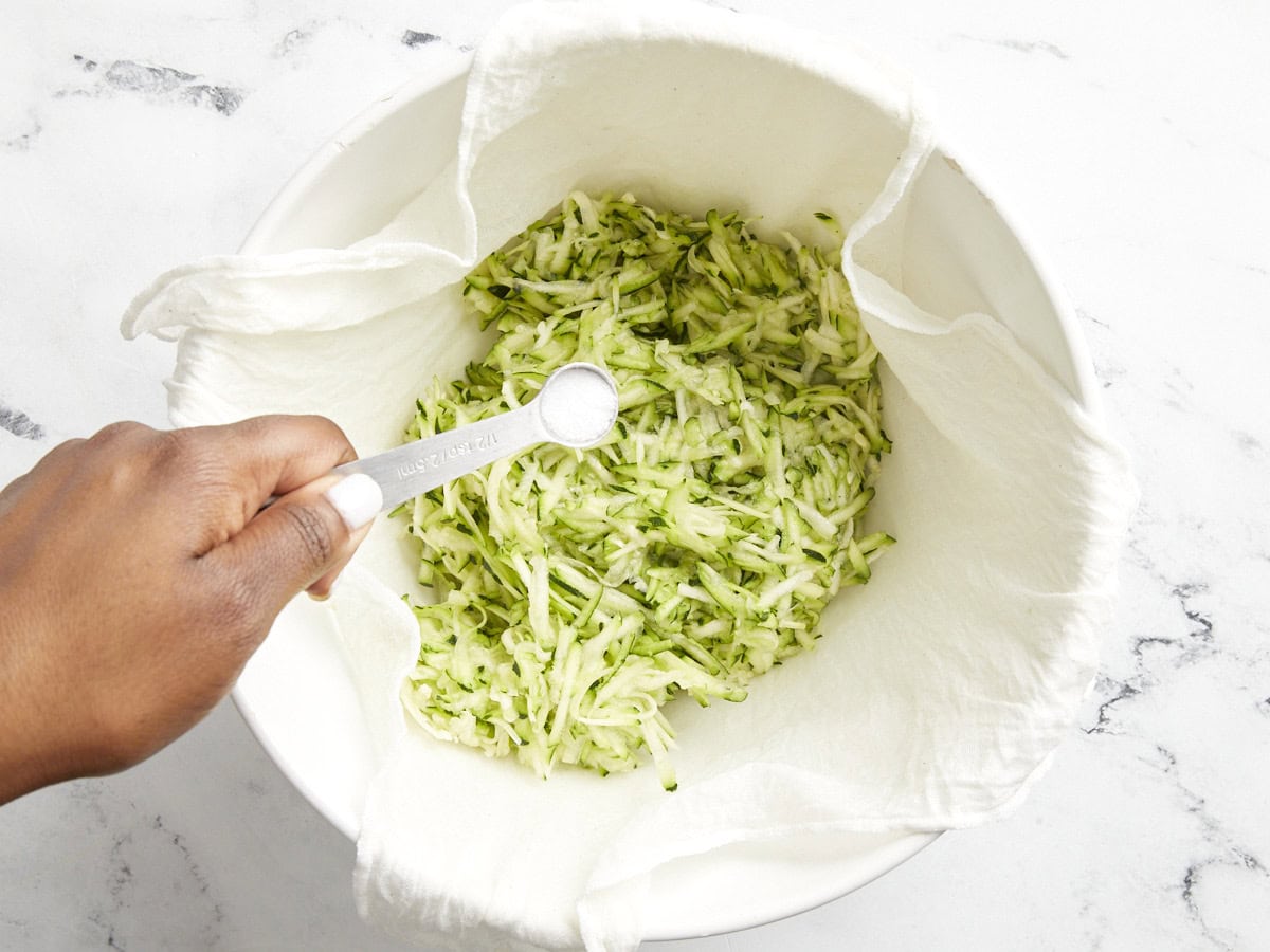 Salt being added to grated zucchini