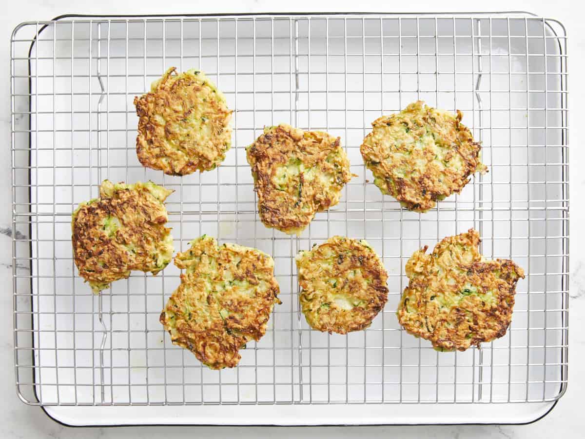 cooked zucchini fritters on a wire rack.