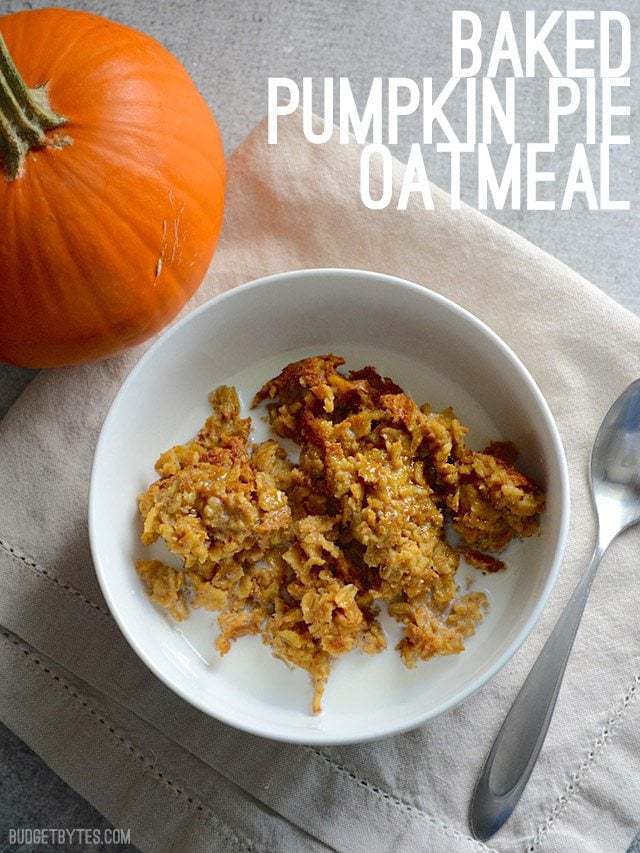 Un tazón de Avena Horneada con Pastel de calabaza con leche vertida encima y una calabaza al lado