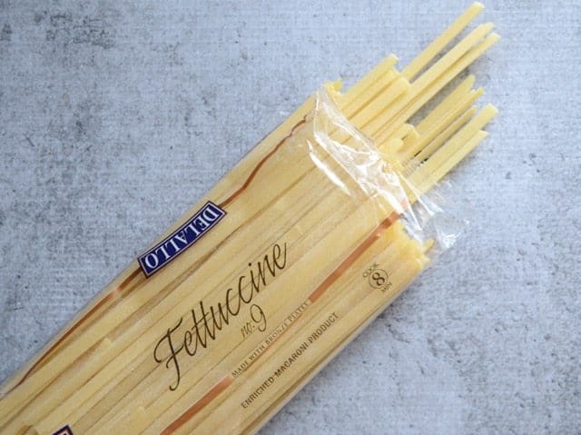 Dry fettuccine package, open, some pasta coming out