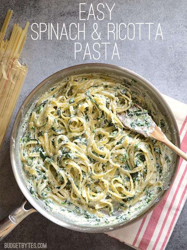 Overhead view of Spinach and Ricotta Pasta in a skillet with a wooden spoon