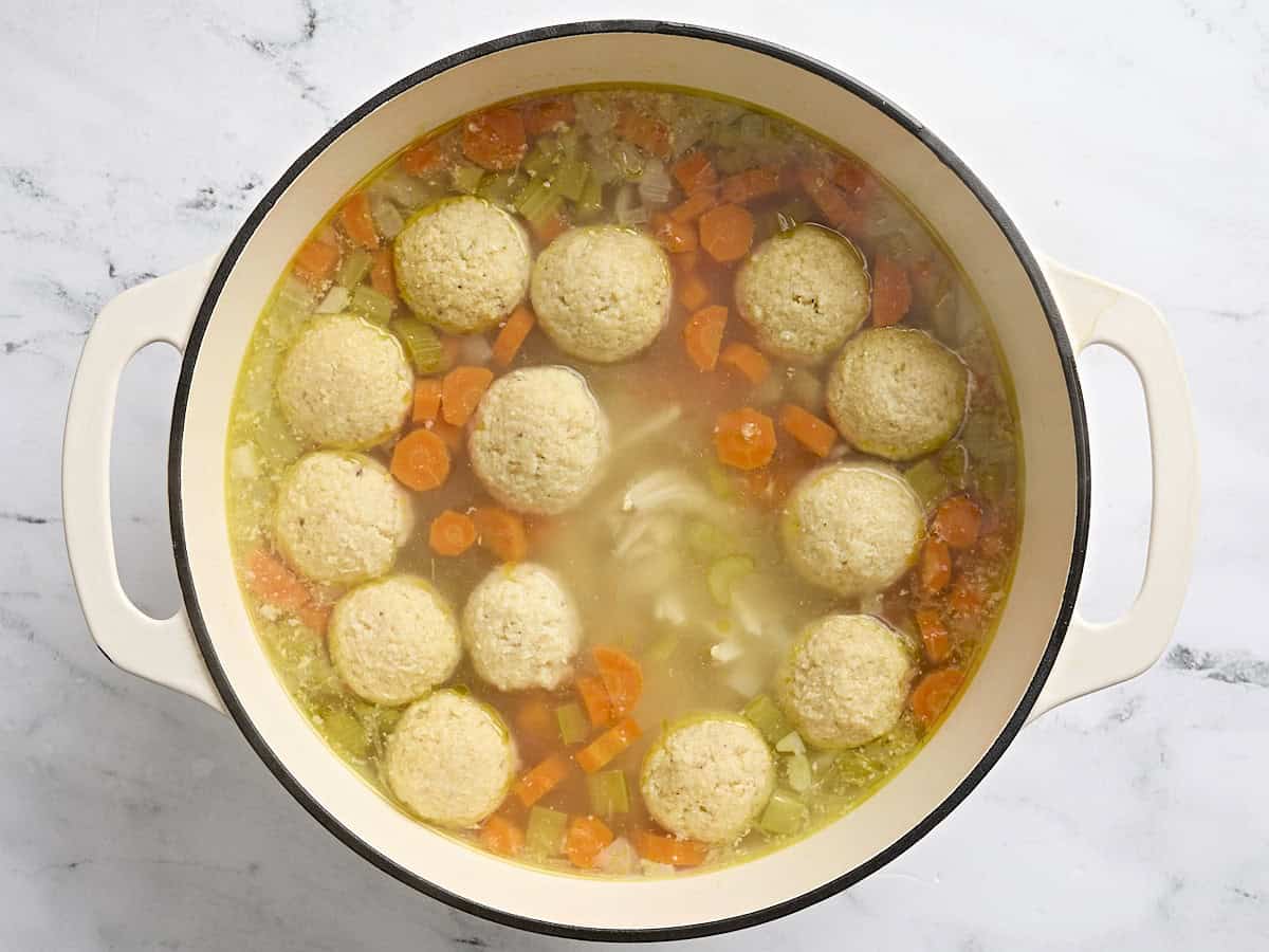 Finished matzo ball soup in a sauce pot.