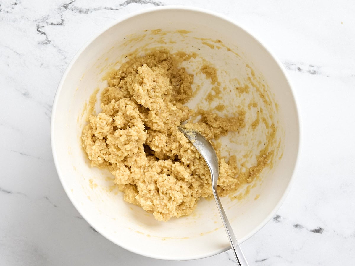 A spoon mixing refrigerated matzo ball dough.