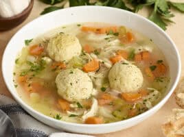 Side view of matzo ball soup in a bowl.