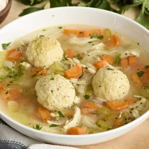 Side view of matzo ball soup in a bowl.