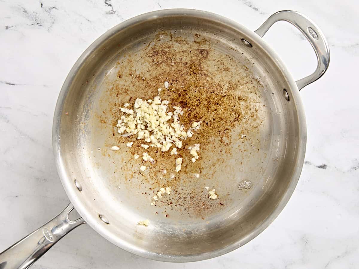 Minced garlic cooking in a skillet.