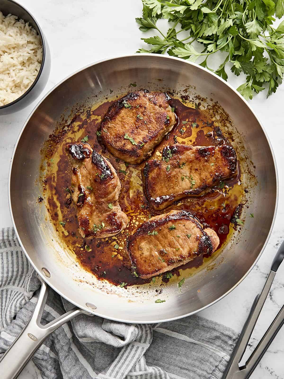 Overhead view of glazed pork chops in a skillet.