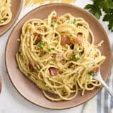 Overhead view of a plate of spaghetti carbonara with a fork.