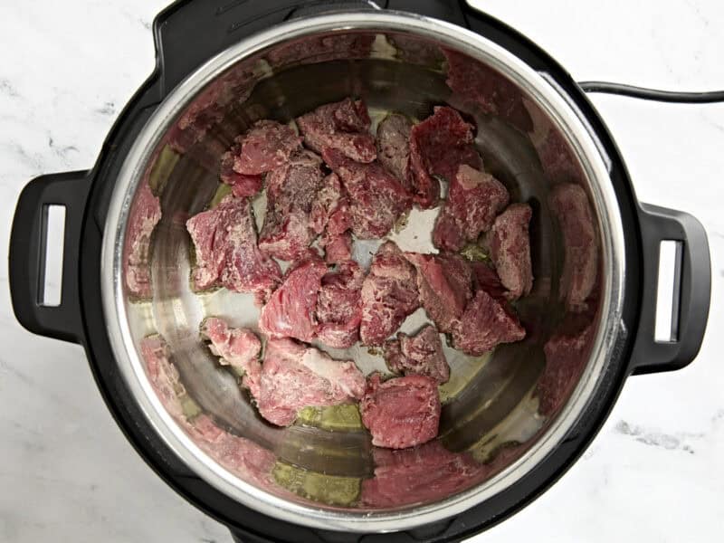 Beef stew meat browning in an Instant Pot.