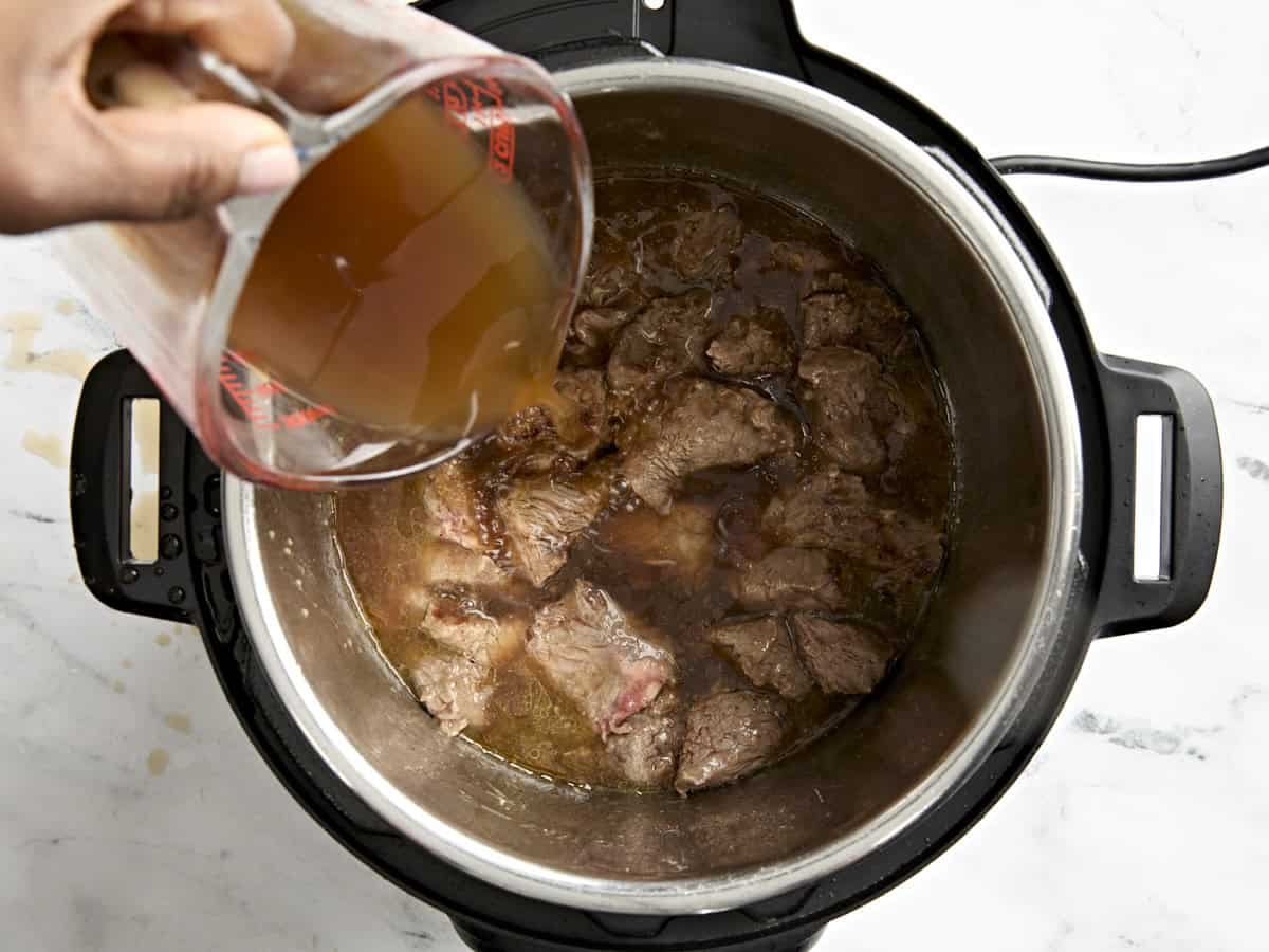 Beef Broth being poured into an Instant Pot.