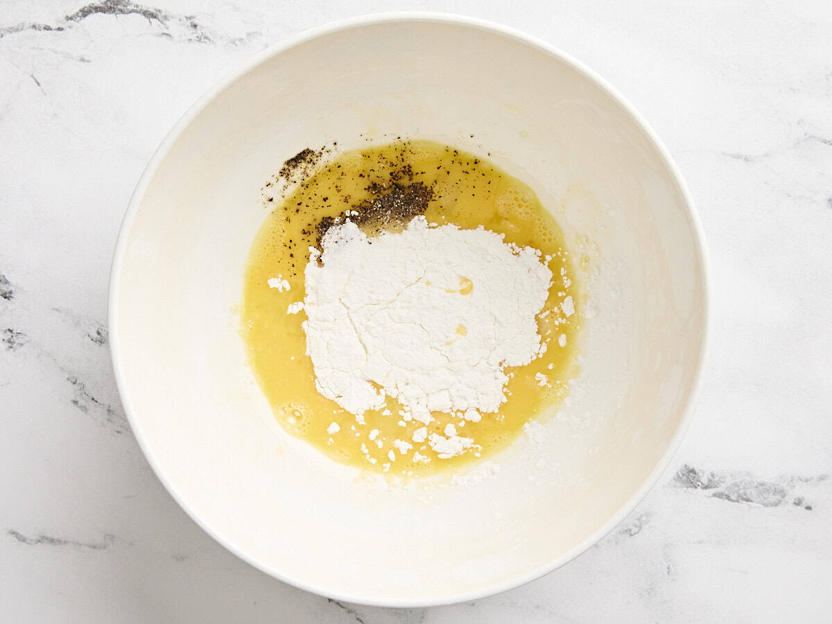 Corn starch, egg, and seasonings in a mixing bowl.