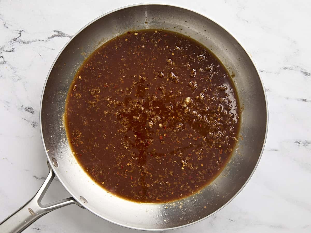 Orange sauce simmering in a skillet.