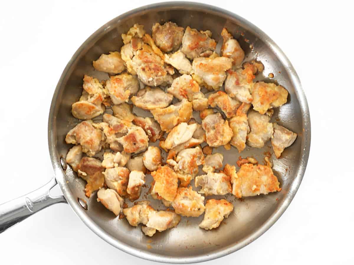 Cooked chicken pieces in a skillet. 