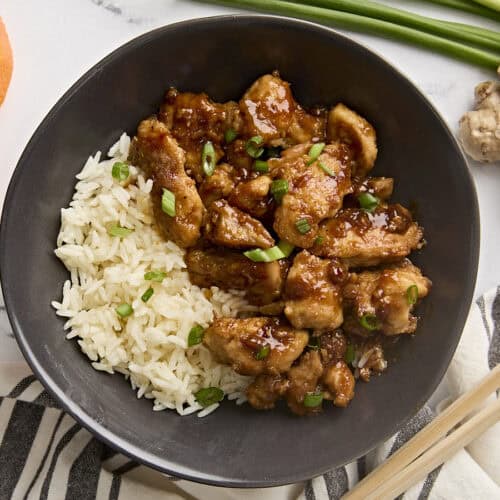 Overhead view of homemade orange chicken in a bowl with rice.