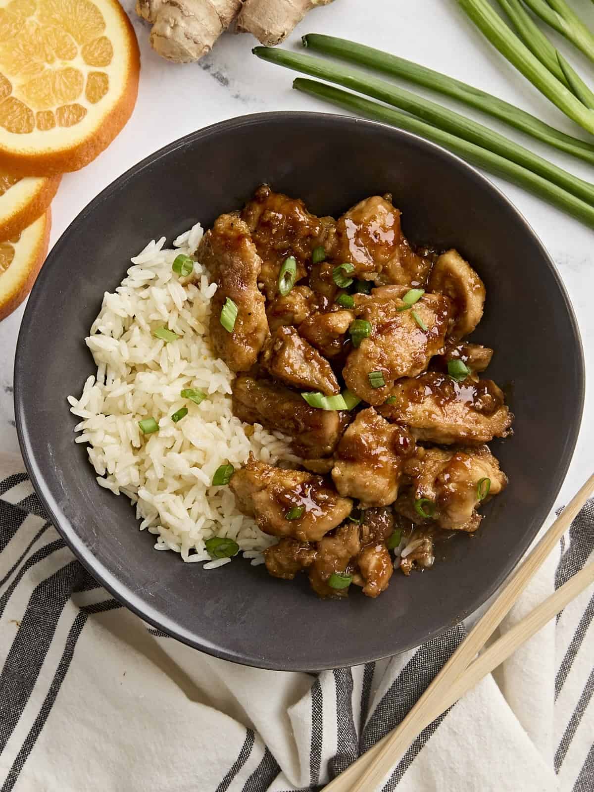 Overhead view of homemade orange chicken in a bowl with rice.