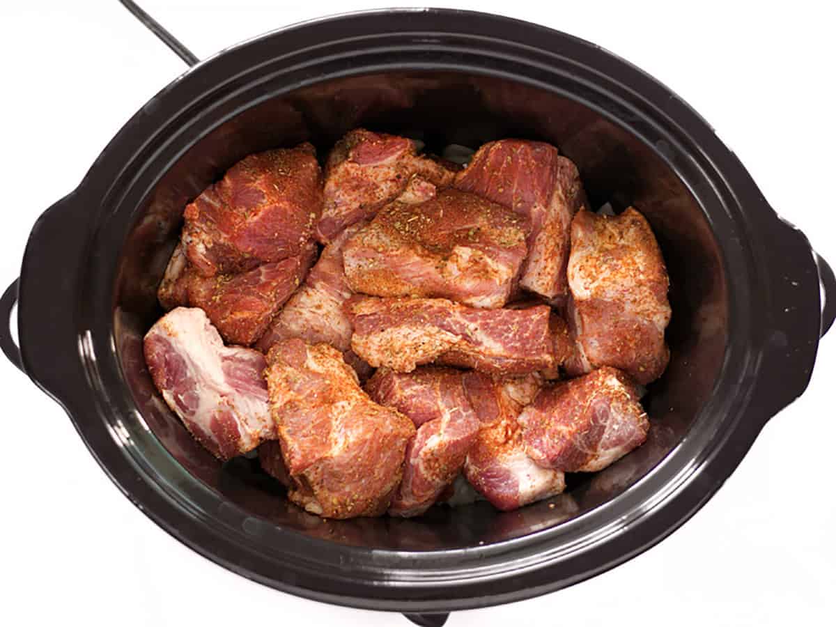 Pork meat coated in spices in the slow cooker.