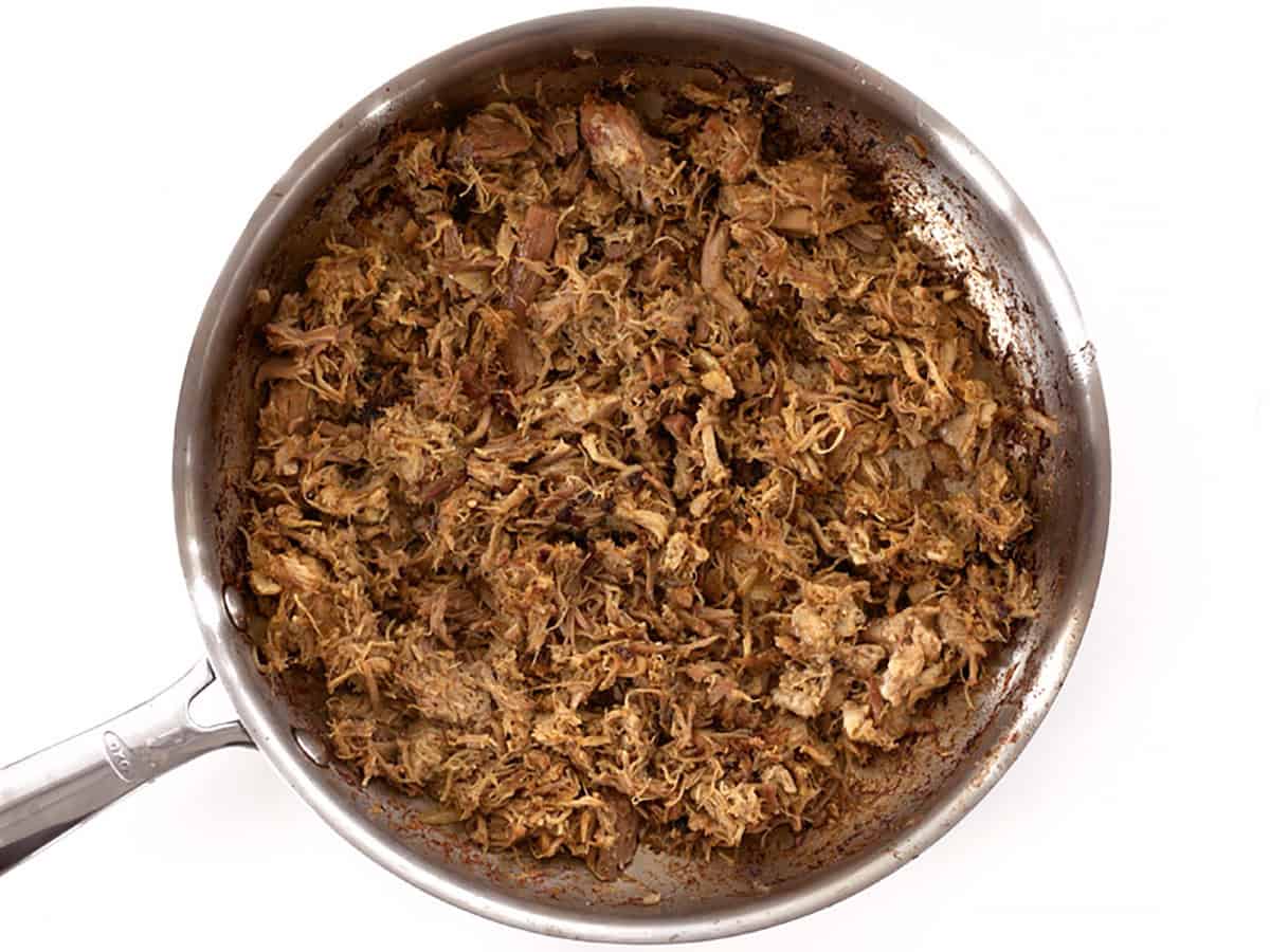 Carnitas in a skillet after frying and getting crispy.