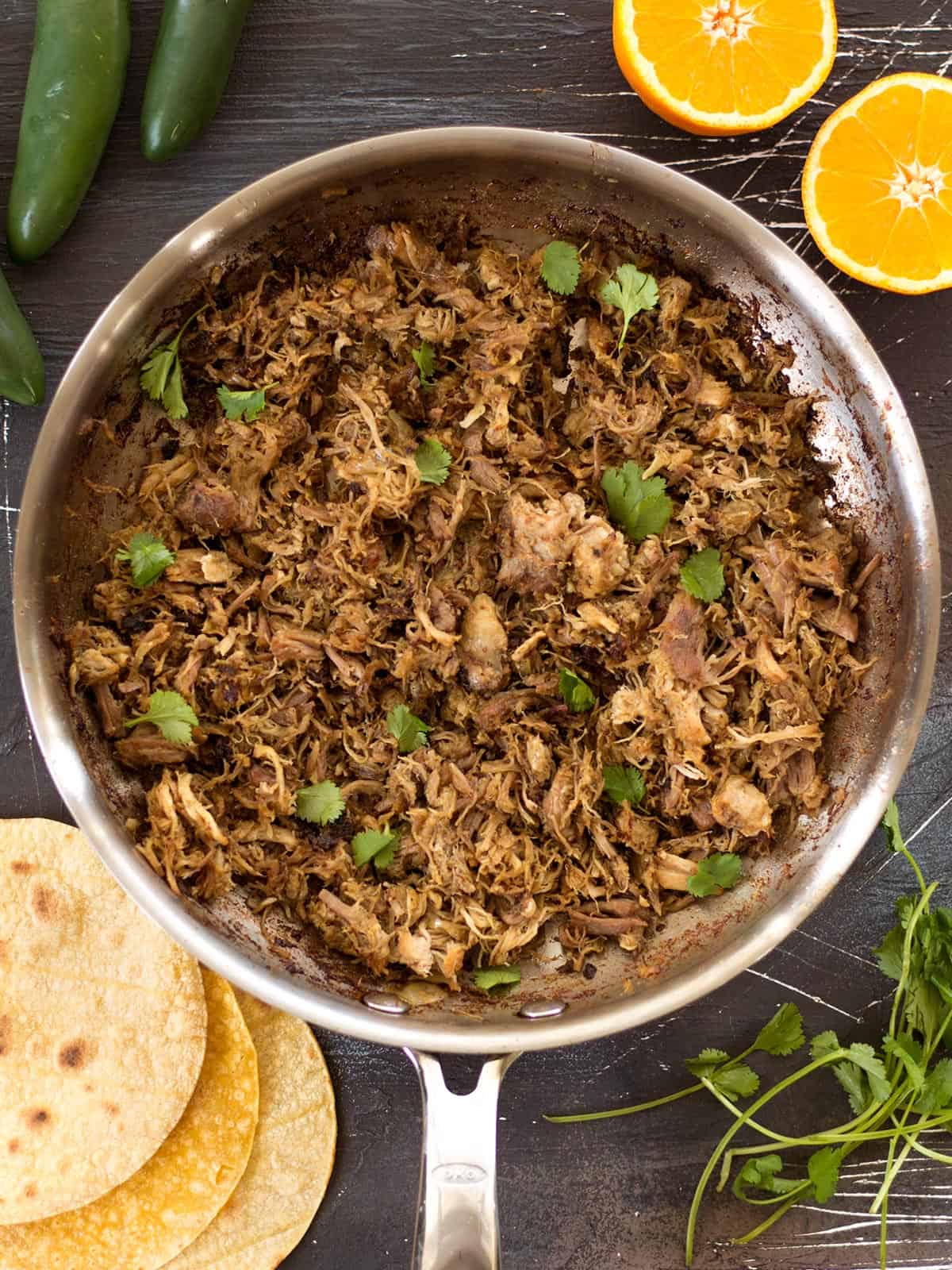 Overhead view of finished slow cooker carnitas in a skillet.