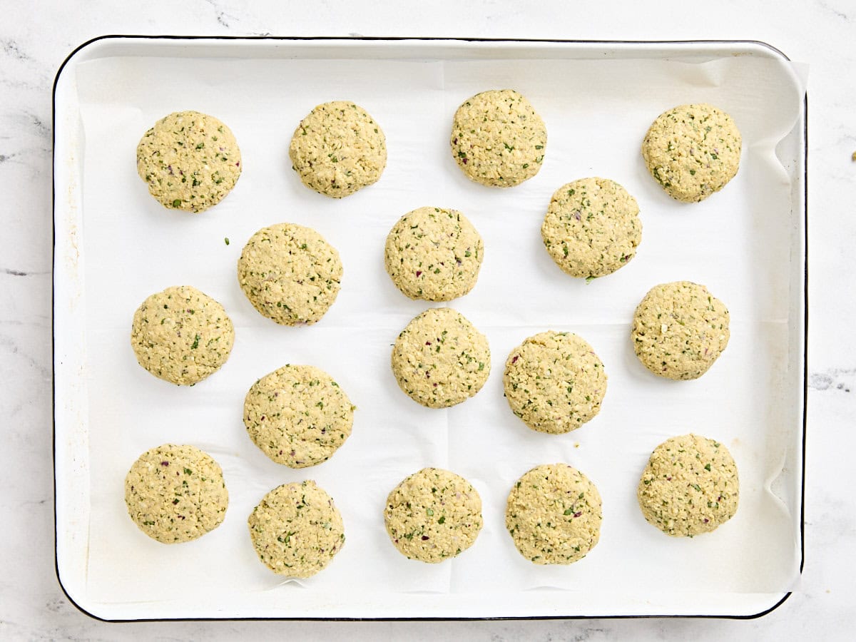 Shaped falafel patties on a baking sheet.