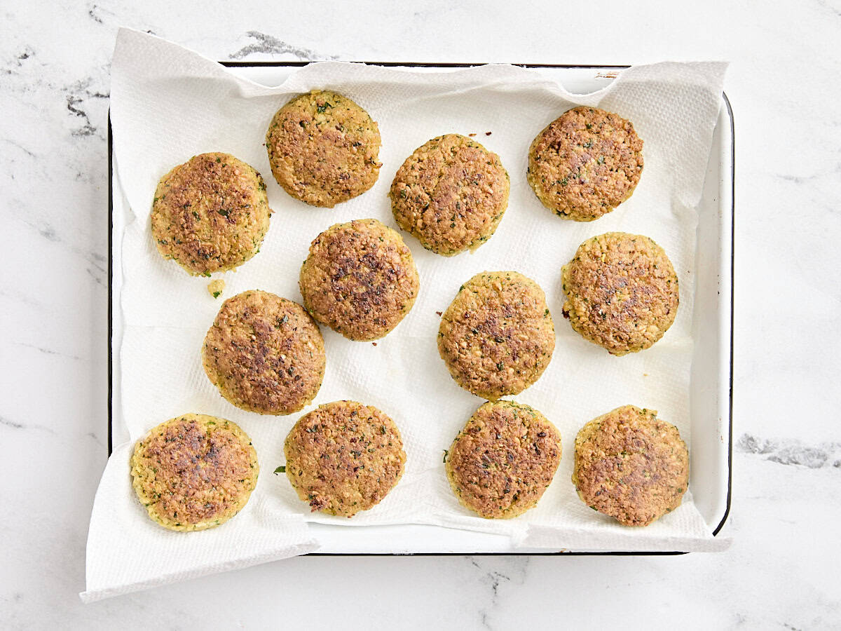 Falafel on a parchment lined baking sheet.