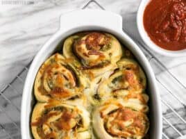 These Pesto Pizza Rolls are a fun way to change up your pizza routine with swirls of cheese, pesto, and pepperoni, plus lots of crispy edges! BudgetBytes.com