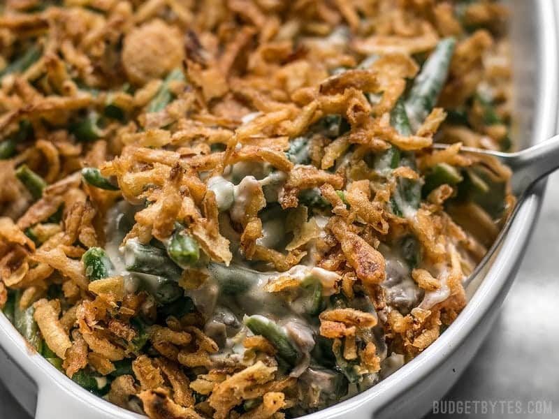 close up of green bean casserole being scooped out of the dish