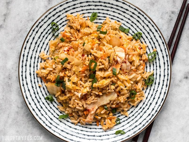 A plate of Kimchi Fried rice with chopsticks on the side