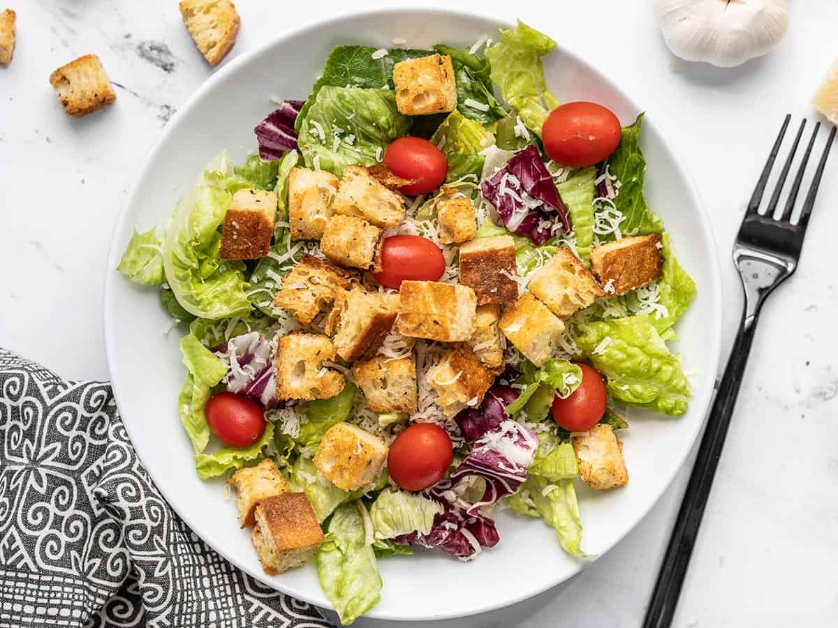 Overhead view of a salad in a bowl topped with homemade croutons.