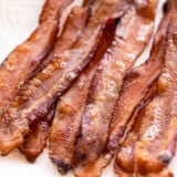 Close up of oven baked bacon on a paper towel.