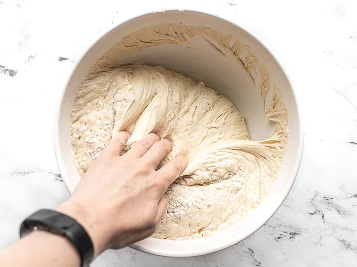 Dough being scraped from the sides of the bowl. 