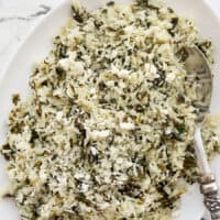 Close up overhead view of spinach rice with feta in a serving dish