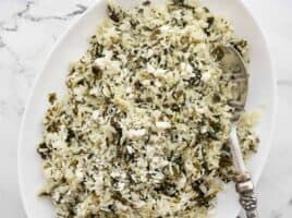 Close up overhead view of spinach rice with feta in a serving dish