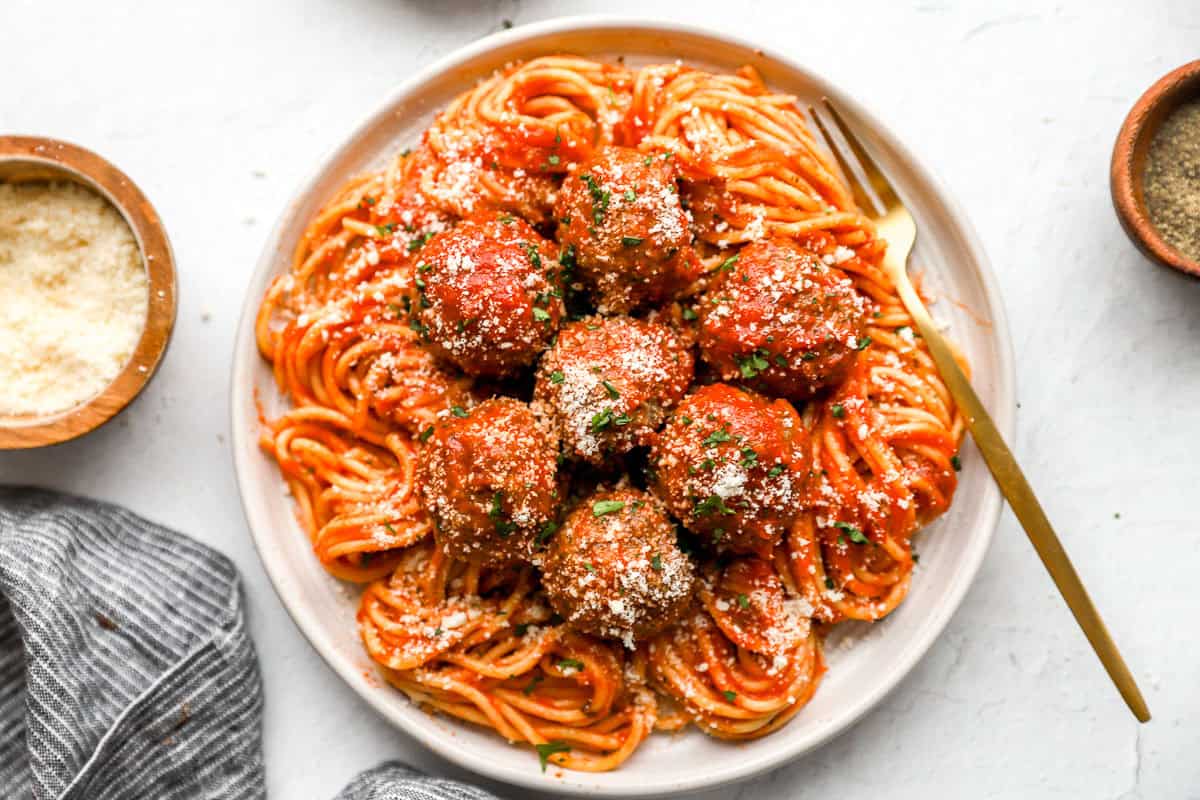 Overhead view of homemade meatballs, marinara sauce, and spaghetti.