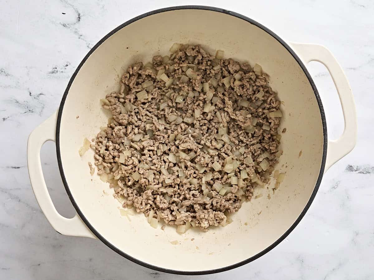 Browned ground beef and diced onion in a soup pot.