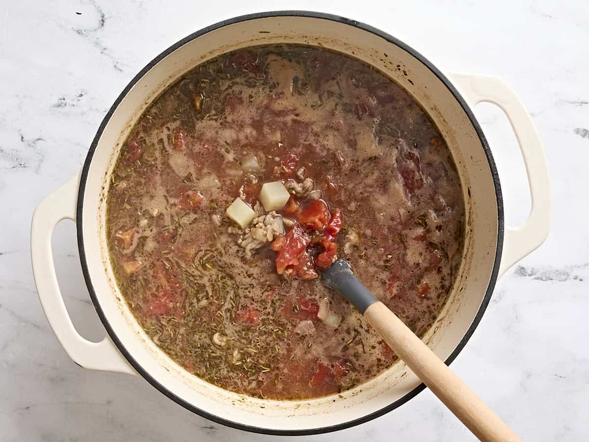 Vegetable beef soup in a soup pot being simmering.