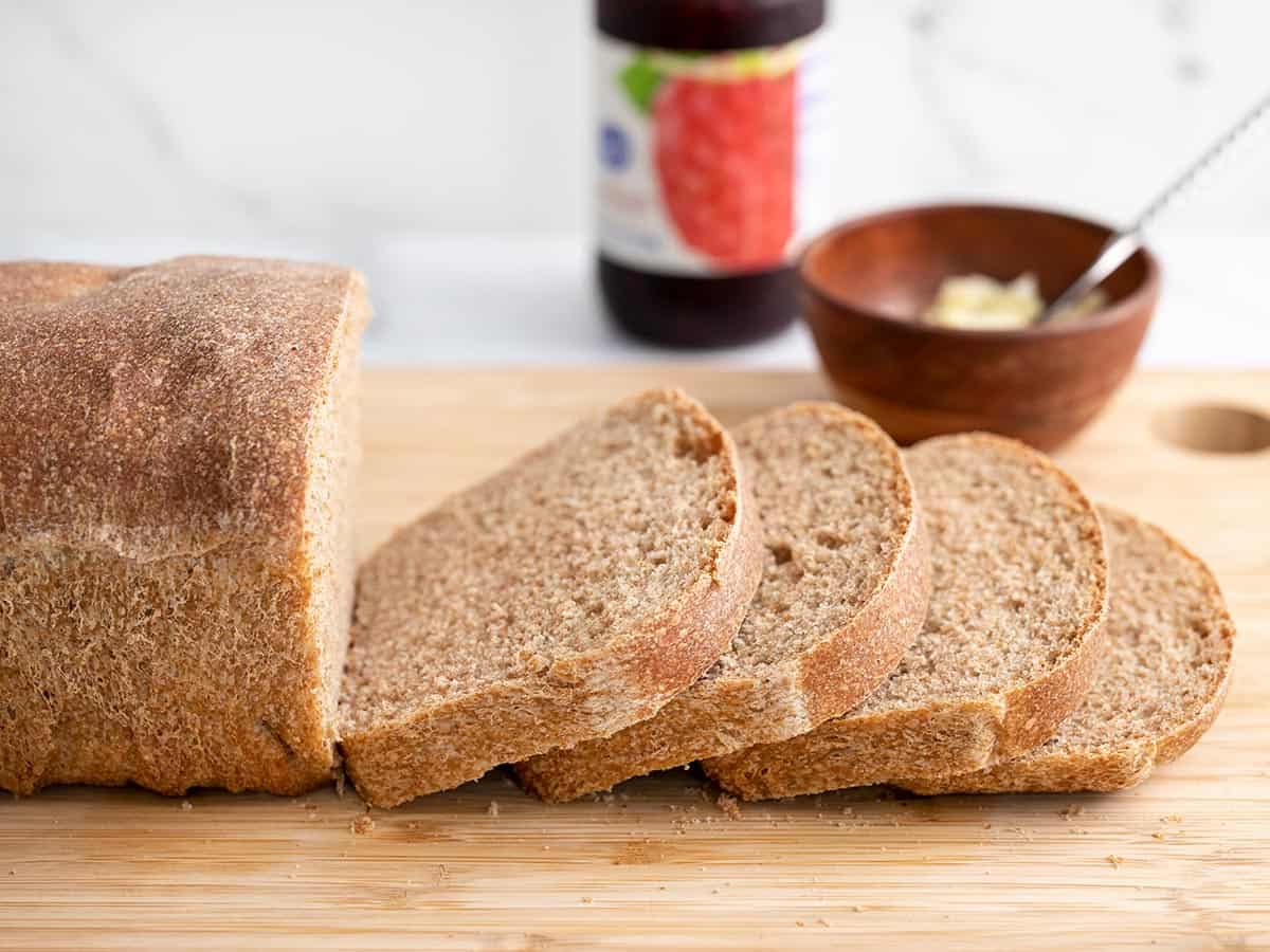 Sliced loaf of whole wheat bread viewed from the side.