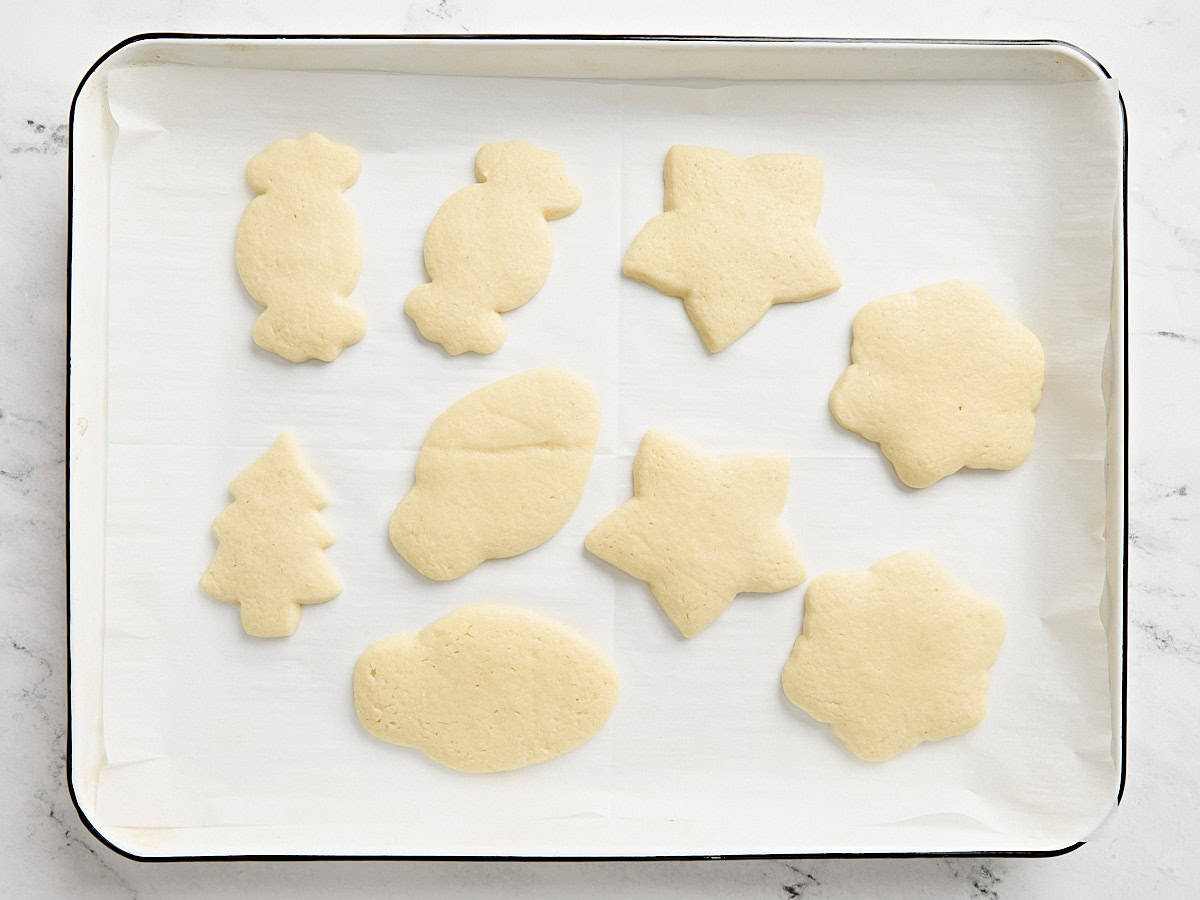 Baked sugar cookies on a parchment lined baking tray.