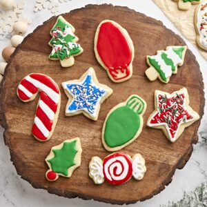 Overhead view of festive sugar cookies on a wooden board.