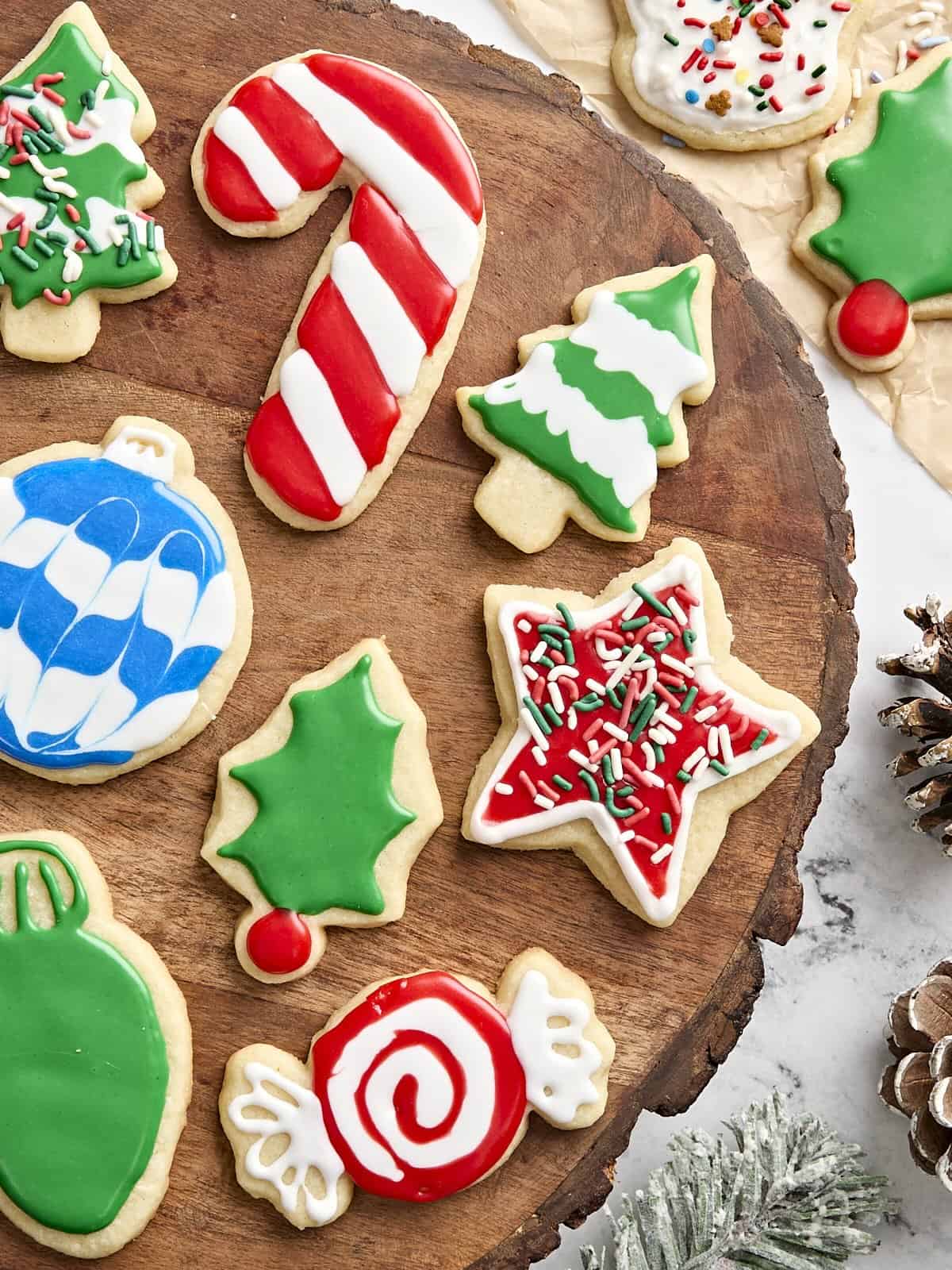 Overhead view of festive sugar cookies on a wooden board.