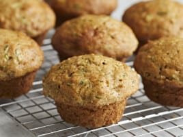 Side view of Zucchini muffins on a wire rack.