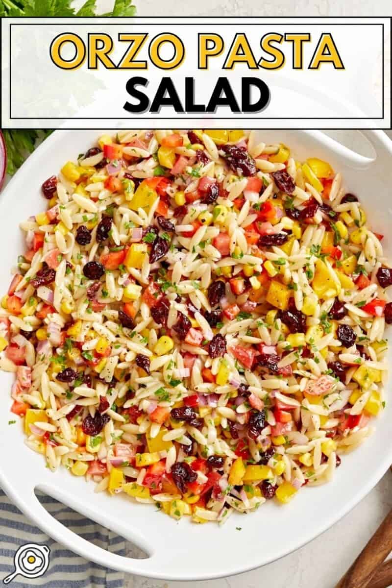 Overhead view of Orzo Pasta Salad in a white serving bowl with title text at the top.
