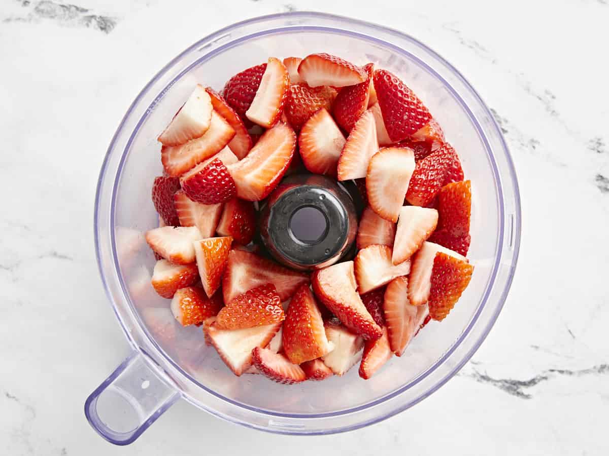 Fresh chopped strawberries added to a food processor.