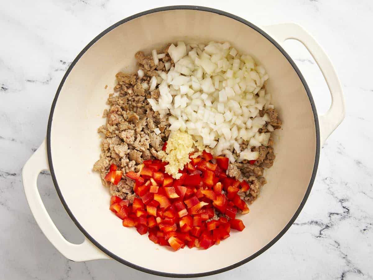 Italian sausage, onions, garlic, and red bell pepper in a dutch oven.