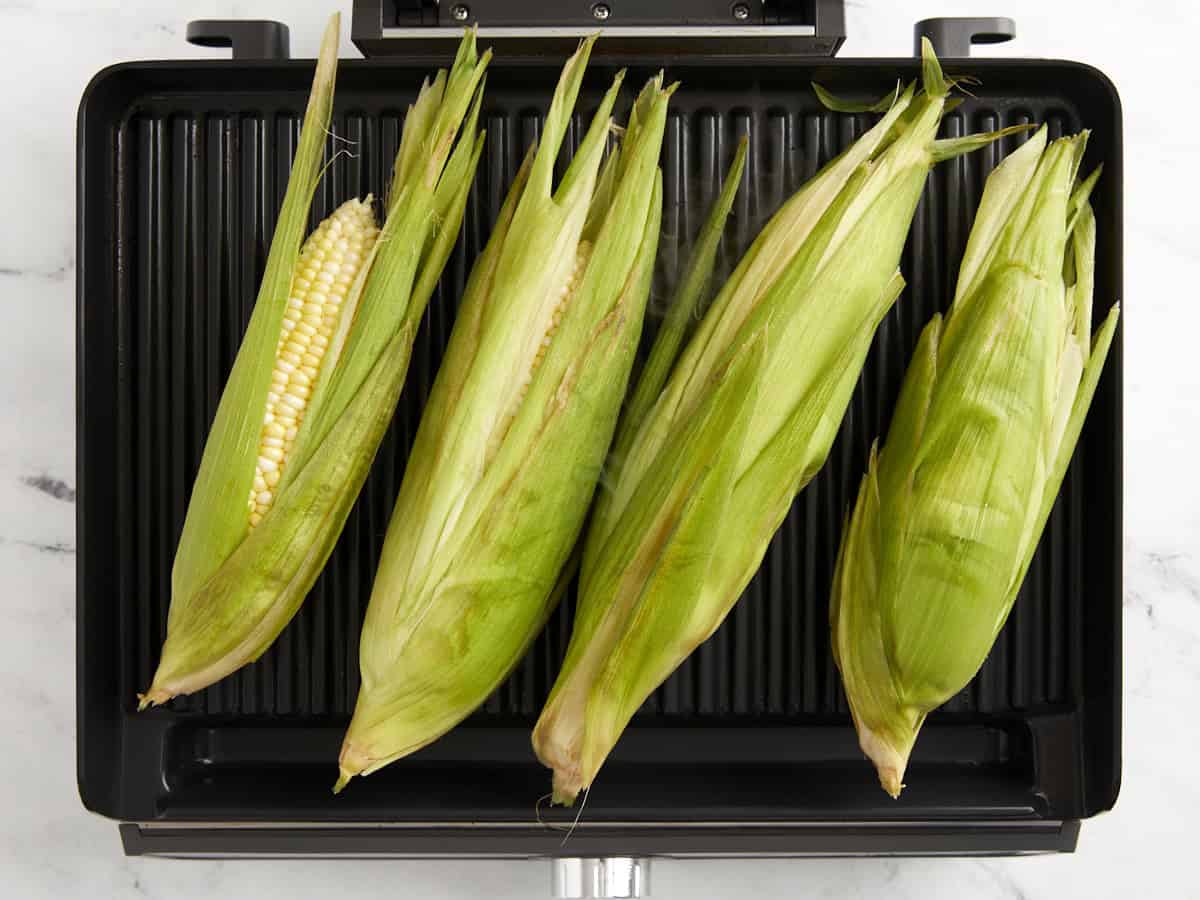 4 ears of corn on a grill pan.