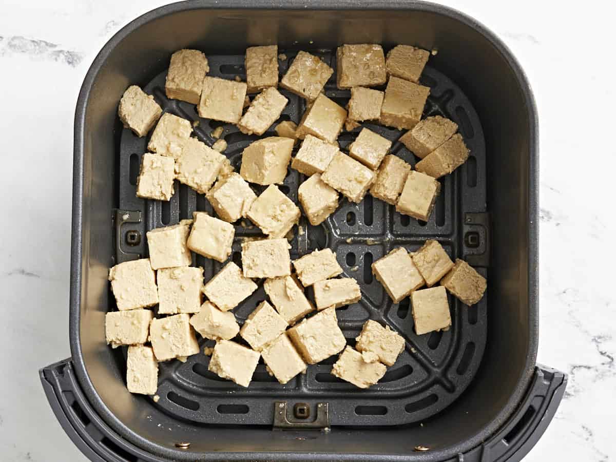 tofu cubes in an air fryer basket.