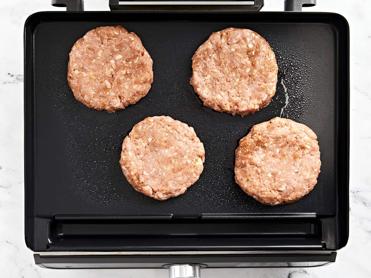 4 turkey burger patties on a grill pan.