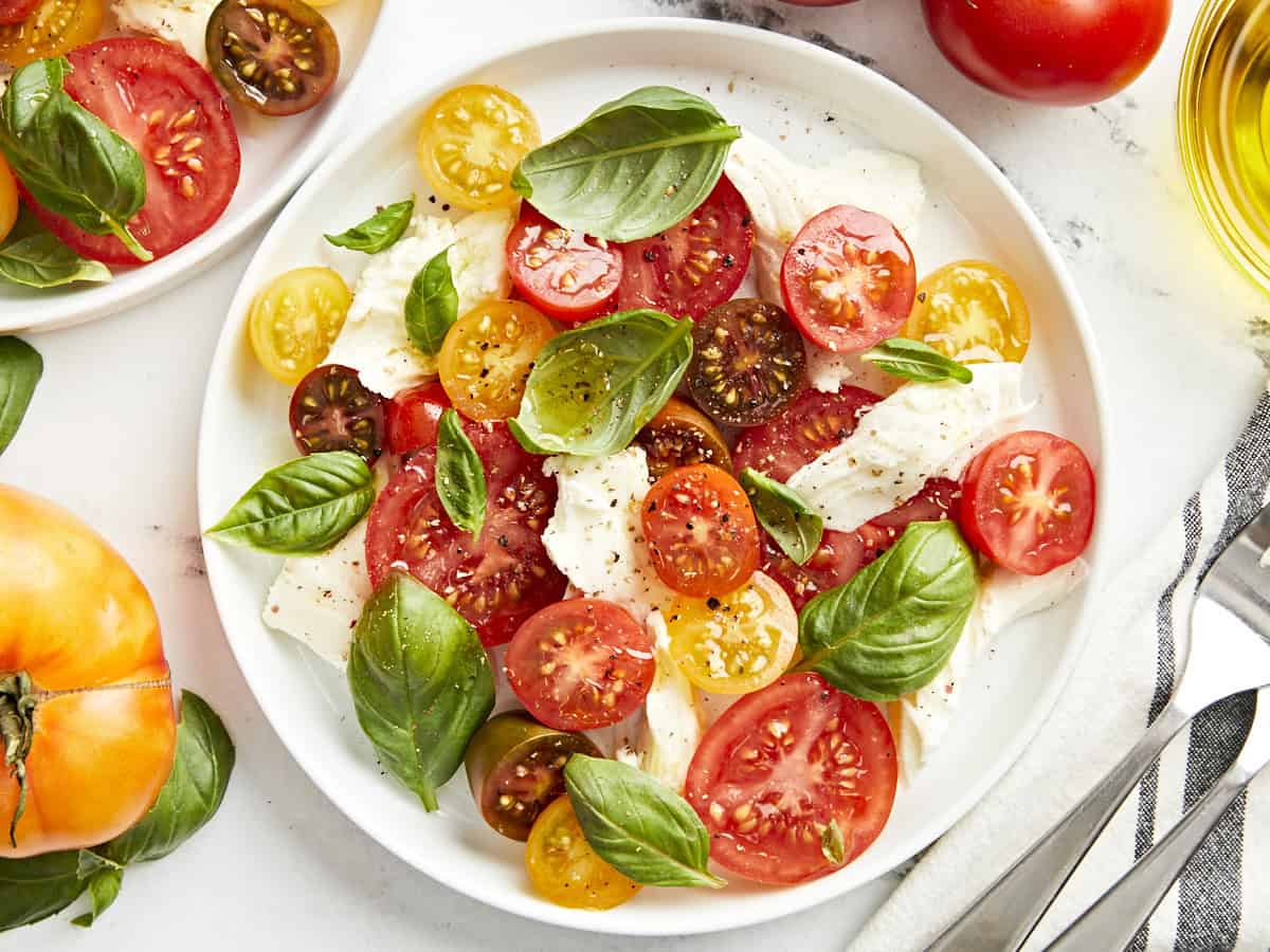 overhead view of a serving of caprese salad on a white plate.