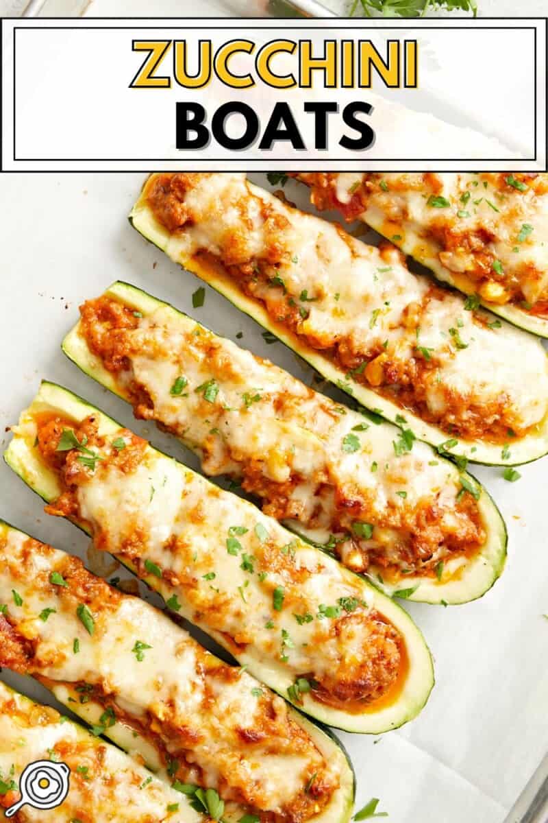 Overhead view of Zucchini boats on a parchment lined baking sheet with title text at the top.