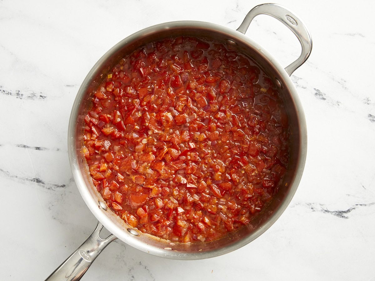 Half-cook tomato relish in a skillet.